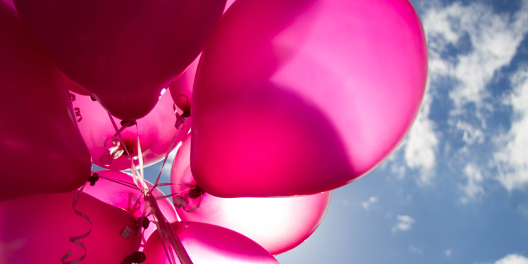 Grosse pinkfarbige Ballons vor blauem Himmel