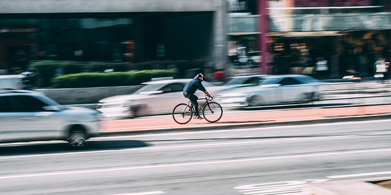 Eine Person fährt mit dem Fahrrad durch die Stadt