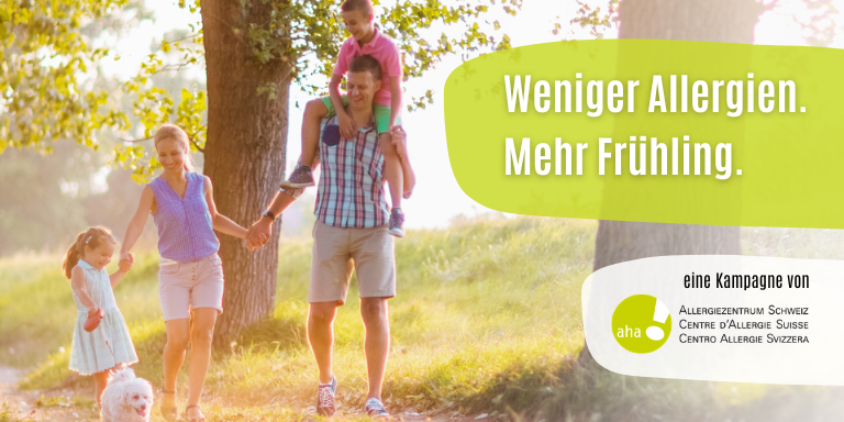 Eine Familie läuft mit ihrem Hund glücklich durch den Wald.