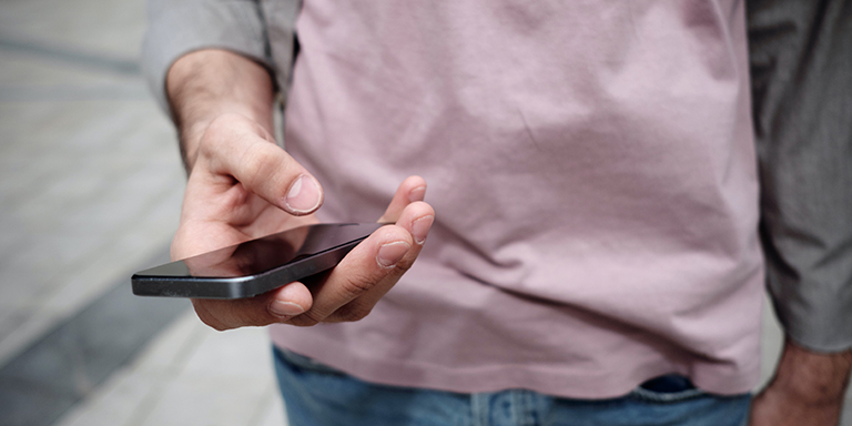 Eine junge Person hält ein Smartphone in der Hand