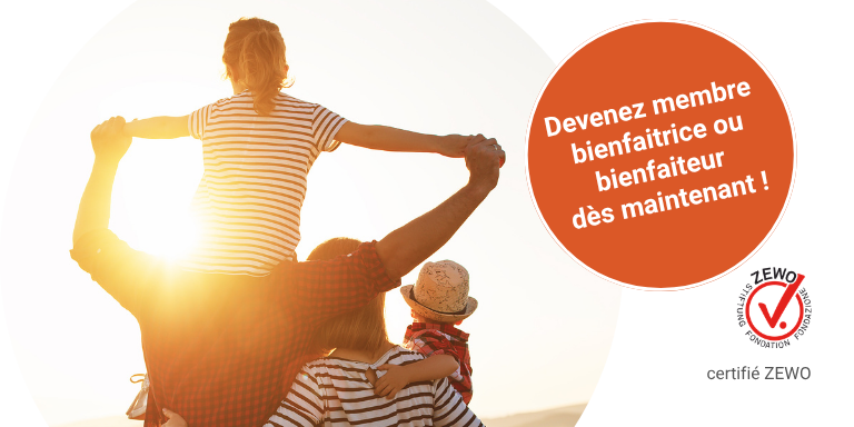 Une famille pose joyeusement dans un champ au coucher du soleil