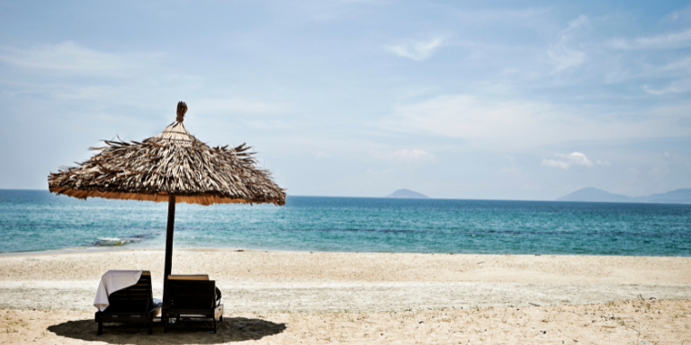 Un parasol et deux chaises longues sur une plage
