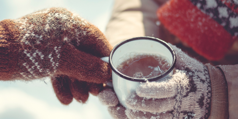 Une personne tient un punch dans sa main pendant la saison froide de l'hiver.