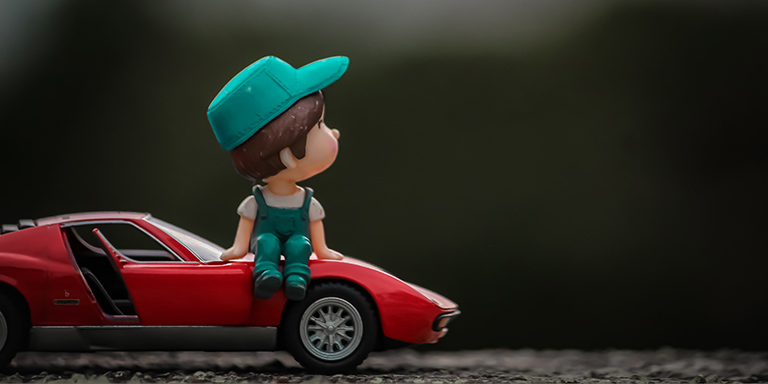Bande dessinée: garçon avec un képi assis sur le capot d'une voiture de sport