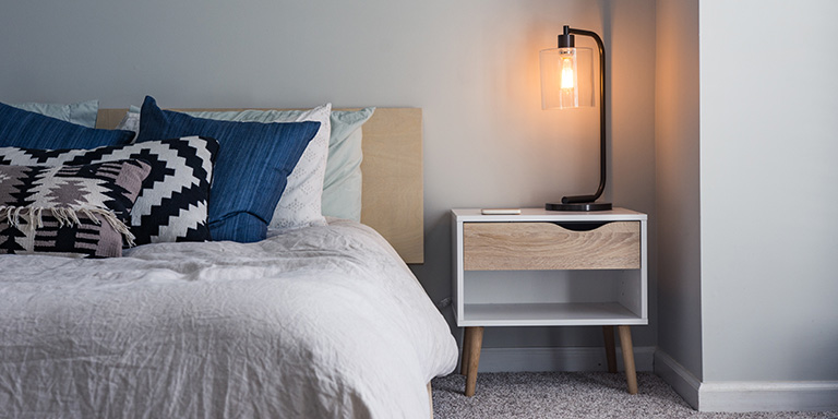 Un lit avec une table de nuit