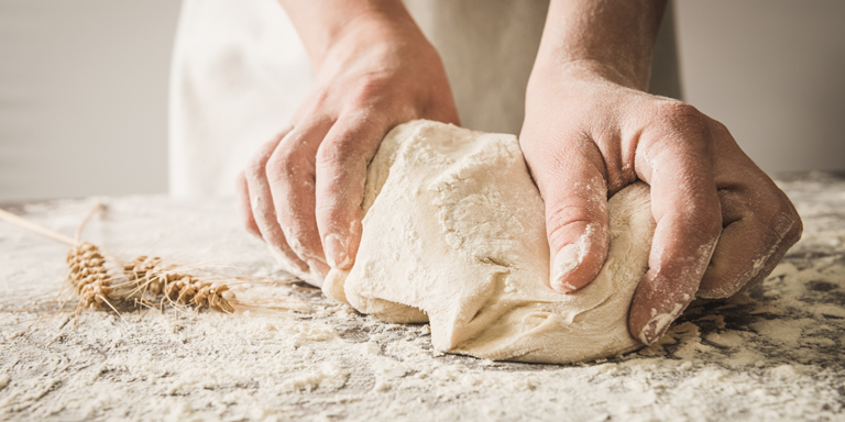 Two hands kneading a dough