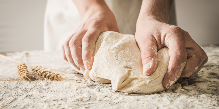 Deux mains pétrissant une pâte