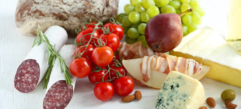 Eine Auslese an Lebensmitteln: Wurst, tomaten, Speck, Roquefort, Nüsse, Mandeln, Trauben, Birne
