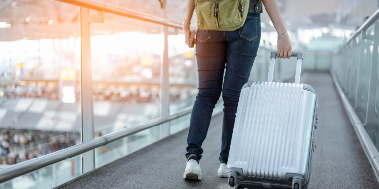 Une personne avec une valise à roulettes à l'aéroport