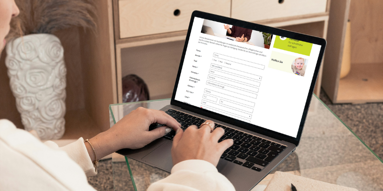 Eine Person füllt das aha!infoline-Formular am Laptop aus.