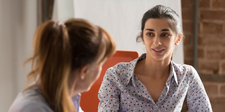 Two young women exchange ideas.