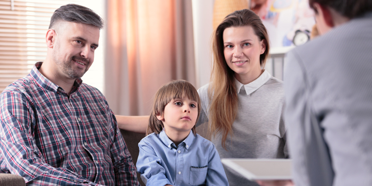 Père, mère et enfant en conversation avec une conseillère ou un conseiller