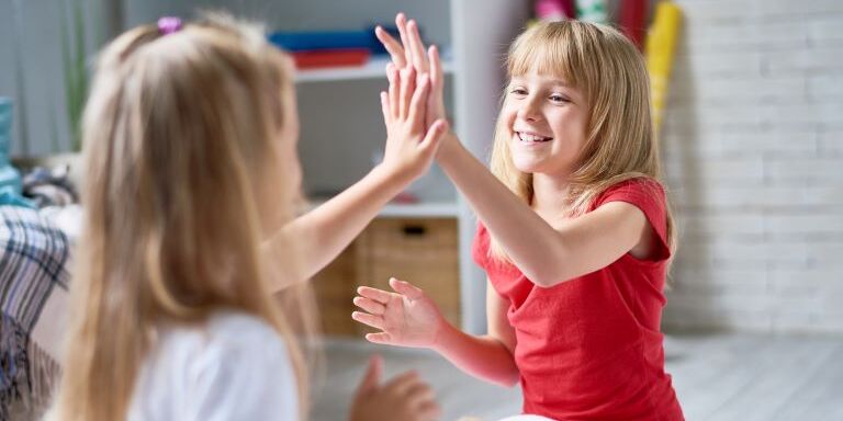 Two younger children practice putting lotion on correctly