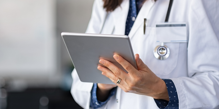 Une femme médecin lit la newsletter sur les offres pour les professionnels sur une tablette.