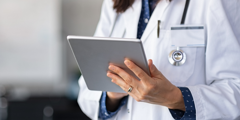 A doctor reads the newsletter on a tablet.