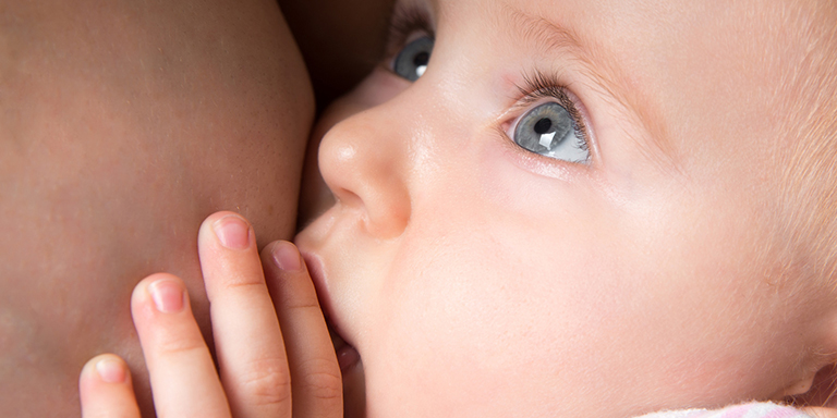 Baby trinkt von der Brust der Mutter.