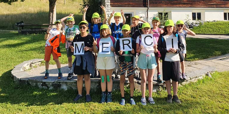 I bambini del campo per bambini reggono le singole lettere.