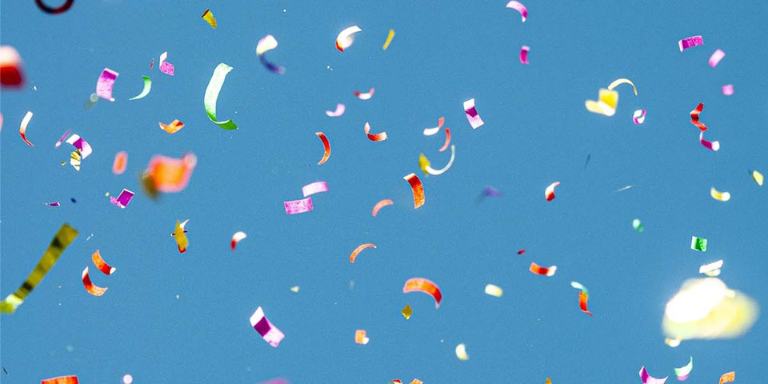 Symbolbild Wettbewerb: Fliegende Konfetti vor einem Himmel